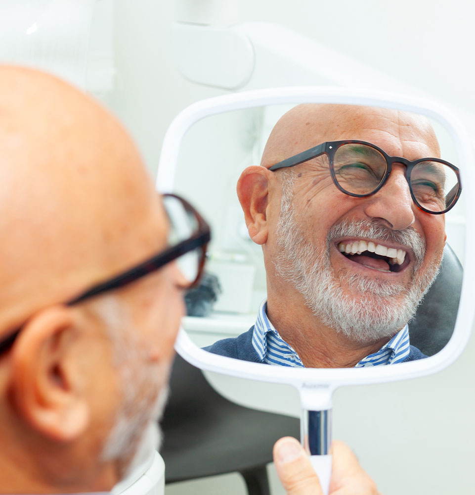 Patient smiling into mirror